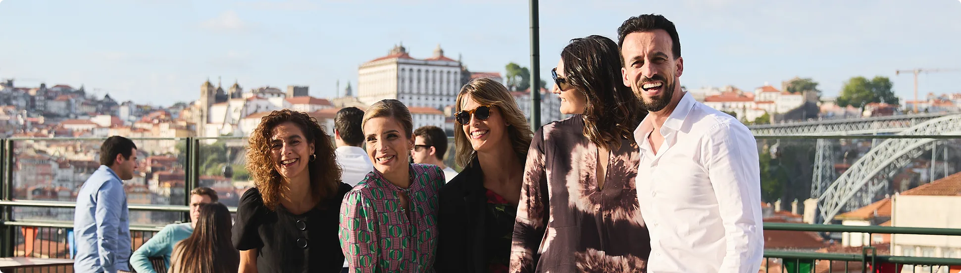 Smiling group on a sunny rooftop in the city.