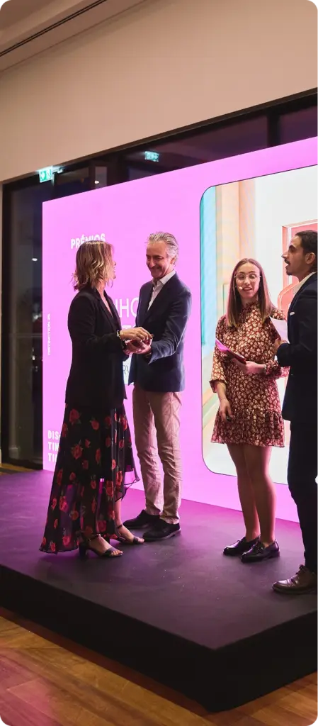 People exchanging a handshake at event stage.